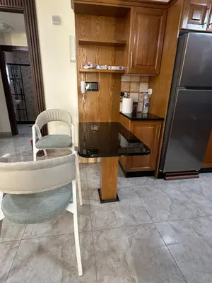 a kitchen with a chair and a table and a refrigerator at Royal in Amman