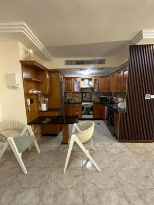 a large kitchen with wooden cabinets and chairs in it at Royal in Amman