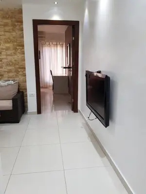 a living room with a flat screen tv on a wall at Waleed's Studio in Amman