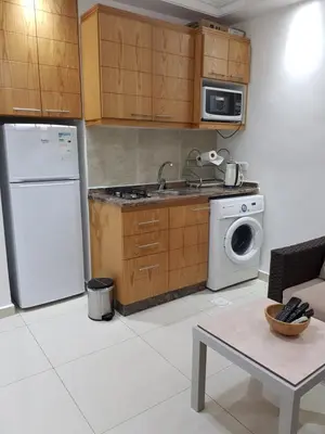 a kitchen with a white refrigerator and a dishwasher at Waleed's Studio in Amman