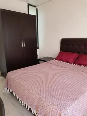 a bedroom with a pink bed and a cabinet at Waleed's Studio in Amman