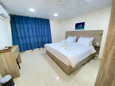 a bedroom with a large bed and a blue curtain at فندق الشلالات العقبه Waterfalls Hotel Aqaba in Aqaba