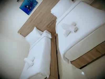 two beds in a hotel room with white pillows at فندق الشلالات العقبه Waterfalls Hotel Aqaba in Aqaba