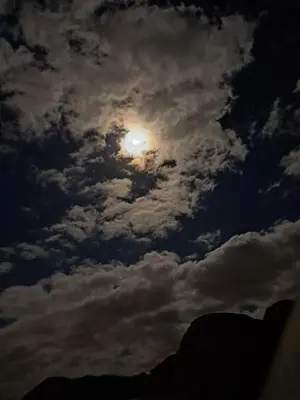 a cloudy sky with the moon in the sky at واي رم in Wadi Rum