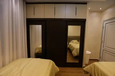 a bedroom with two beds and a large mirror at A luxurious apartment for relaxation in Amman in Amman
