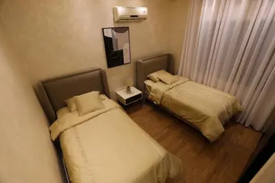 two beds in a small room with a mirror at A luxurious apartment for relaxation in Amman in Amman
