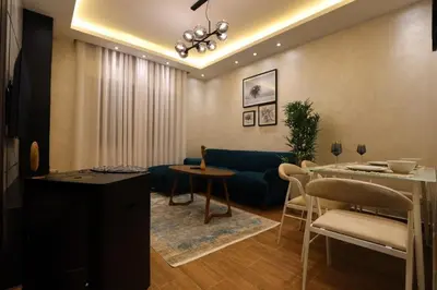 a living room with a blue couch and a table at A luxurious apartment for relaxation in Amman in Amman