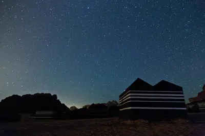 a black and white building under a starry sky at Panorama Wadi Rum Sunset Camp in Wadi Rum