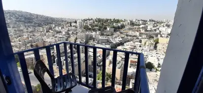 a view of a city from a balcony at citadel mountain sun guest house in Amman