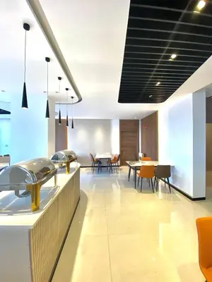 an open kitchen with tables and chairs in a building at Aysel Hotel in Aqaba