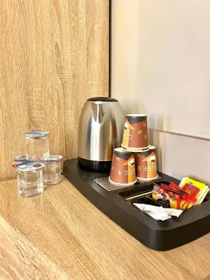 a tray with a coffee pot and cups on a counter at Aysel Hotel in Aqaba