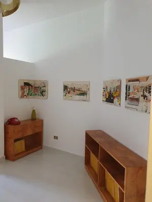 a room with a table and pictures on the wall at One-of-Kind home - city & nature in Amman