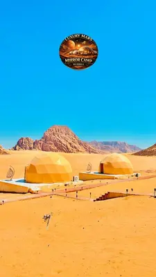a kite is flying over a desert with domes at MARS MIRROR BUBBLE lUXURY CAMP in Wadi Rum