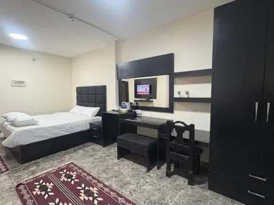 a bedroom with a bed and a desk with a computer at Qastal Zaman in Amman