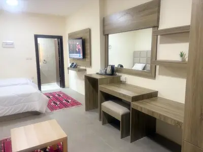 a bedroom with a bed and a desk and a mirror at Qastal Zaman in Amman