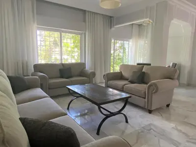 a living room with couches and a coffee table at Bright & Spacious, Upscale Amman in Amman