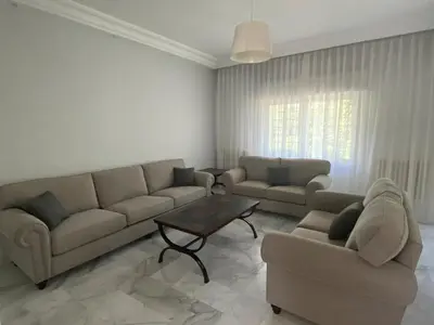 a living room with two couches and a coffee table at Bright & Spacious, Upscale Amman in Amman