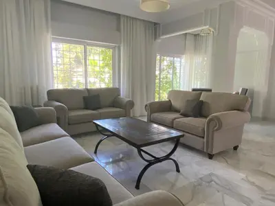 a living room with couches and a coffee table at Bright & Spacious, Upscale Amman in Amman