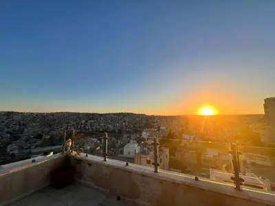 a view of the sunset from the top of a building at Modern, fully equipped apartment in Jabal Amman in Amman