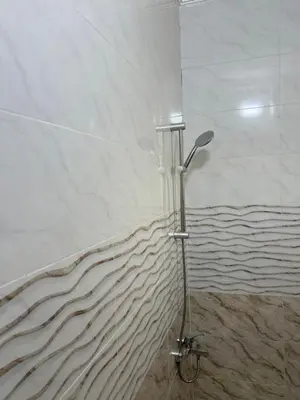 a shower with a shower head in a bathroom at شقه مفروشه حديثة ذات أطلالة جميلة ومكان هادئ in Irbid