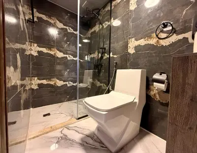 a bathroom with a toilet and a glass shower at Beit Ahlan in Amman