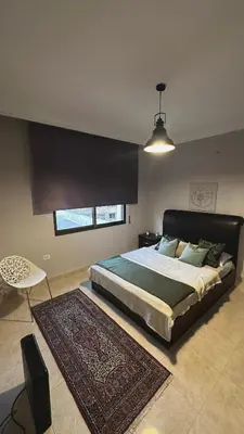 a bedroom with a large bed and a rug at The Elysium in Amman