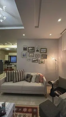 a living room with a couch and pictures on the wall at The Elysium in Amman
