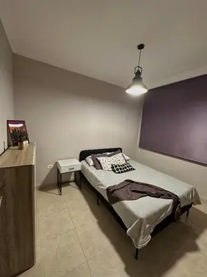 a bedroom with a bed and a purple wall at The Elysium in Amman