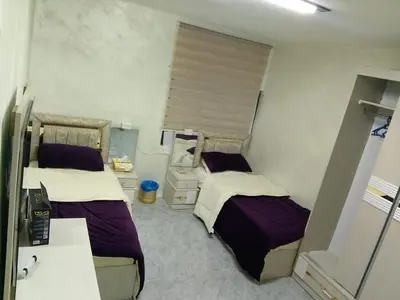 a small room with two beds and a sink at Ahmad Hostel in Kerak
