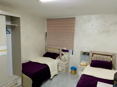 two beds in a room with purple and white at Ahmad Hostel in Kerak