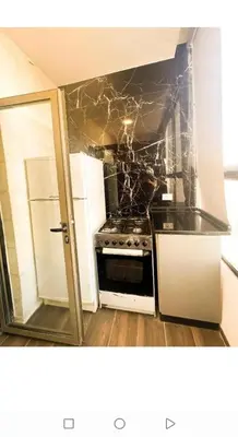 a kitchen with a stove and a white refrigerator at الجوهره in Amman