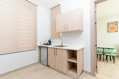 a kitchen with a counter and chairs in a room at Diamond Palm Hotel & Resort in Al Burj