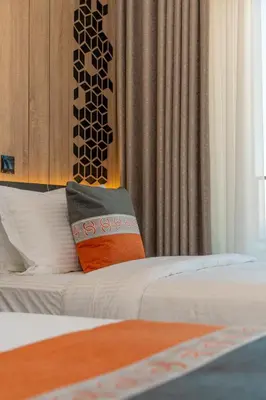a hotel room with a bed with a pillow on it at Diamond Palm Hotel & Resort in Al Burj