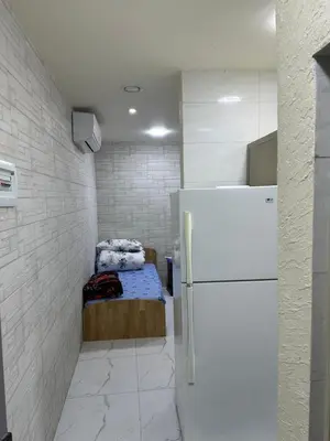 a small room with a bed and a refrigerator at عمان in Amman