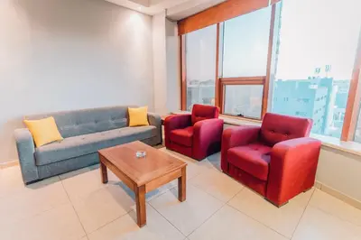 a living room with couches and chairs and a table at Baden Hotel Suites in Amman