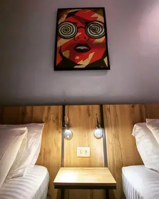 a room with two beds and a painting on the wall at Baden Hotel Suites in Amman