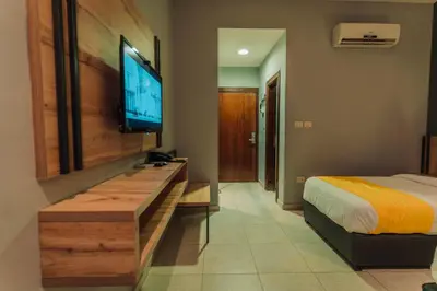a bedroom with a bed and a flat screen tv at Baden Hotel Suites in Amman