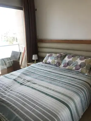 a bed with a striped comforter in a bedroom at Abdoun studio in Amman