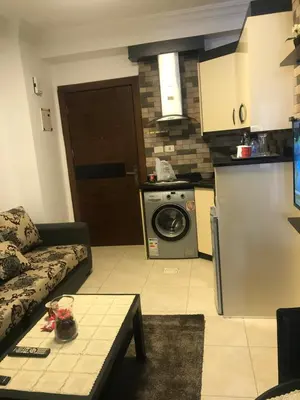 a living room with a couch and a kitchen at Abdoun studio in Amman