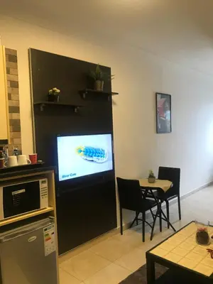 a living room with a television and a table at Abdoun studio in Amman