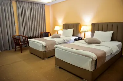 a hotel room with two beds and a chair at 7Wonders by TREND in Petra