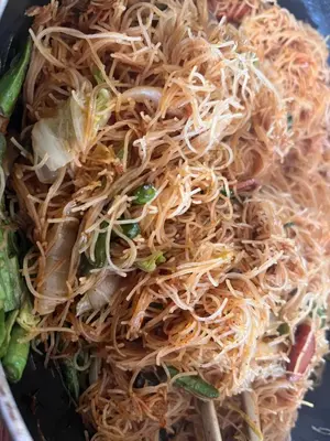 a bowl of noodles and vegetables on a table at \u9f99\u95e8\u5ba2\u6808 in Amman