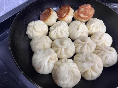 a bunch of dumplings in a frying pan at \u9f99\u95e8\u5ba2\u6808 in Amman