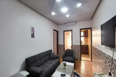 a living room with a couch and a tv at Al-Nujoom Hotel Suites in Amman