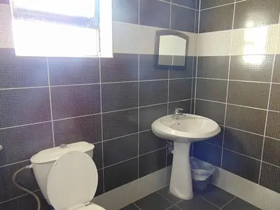 a bathroom with a toilet and a sink at Al-Nujoom Hotel Suites in Amman