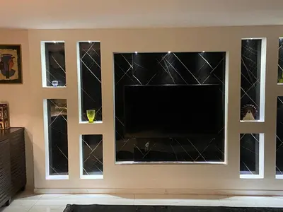 a living room with a tv in a wall with four windows at CityHaven in Amman