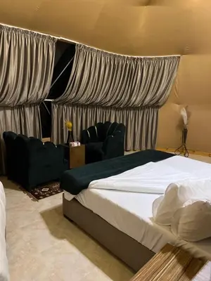 a bedroom with a large bed and a couch at HOlIDAY LUXURY WADI RUM in Wadi Rum