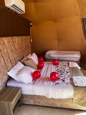 a bedroom with two beds with red balloons on them at HOlIDAY LUXURY WADI RUM in Wadi Rum