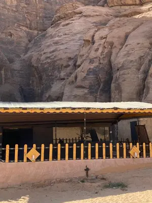 a building in front of a rocky mountain at Fig Tree Eco Camp in Disah