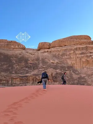 two people walking in the sand in the desert at Alkaram luxury camp in Wadi Rum